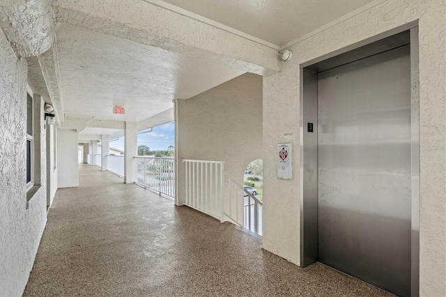 corridor featuring a textured ceiling and elevator