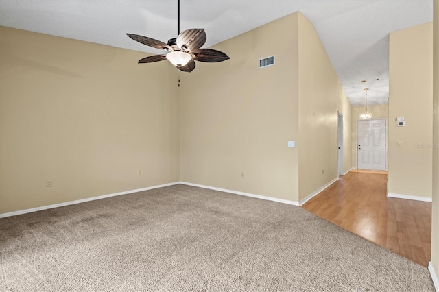 carpeted empty room featuring ceiling fan and vaulted ceiling