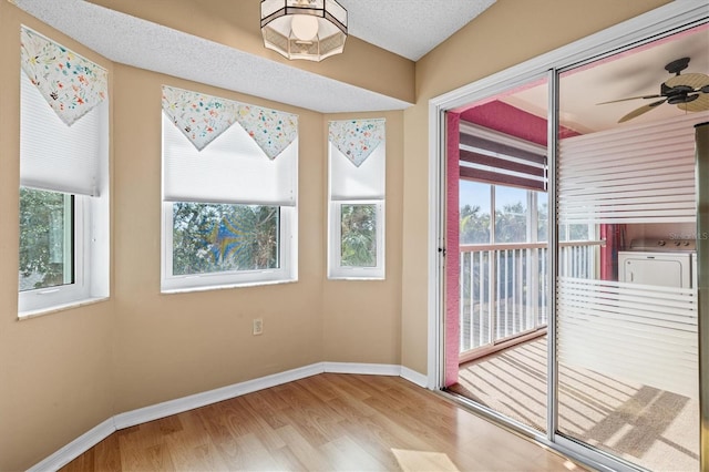 entryway featuring washer / dryer, a textured ceiling, light hardwood / wood-style flooring, and ceiling fan