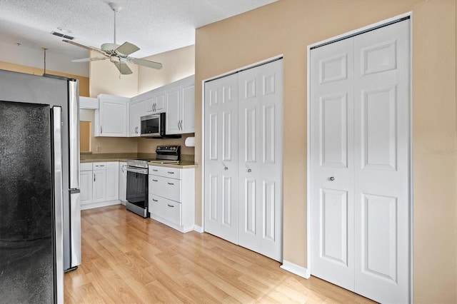 kitchen featuring white cabinetry, ceiling fan, stainless steel appliances, light hardwood / wood-style flooring, and a textured ceiling