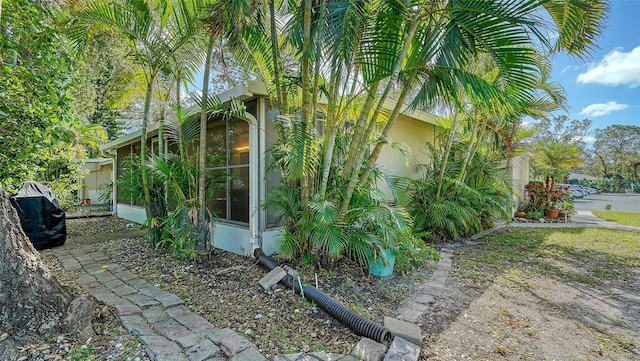 view of property exterior with a sunroom and stucco siding