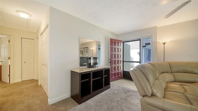 carpeted living room featuring a textured ceiling and ceiling fan