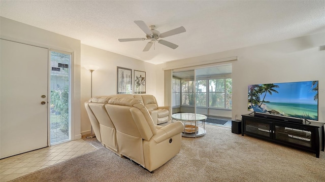 living room featuring a textured ceiling, light carpet, and ceiling fan