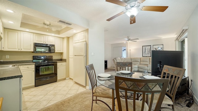 kitchen featuring black appliances, a textured ceiling, sink, light tile patterned flooring, and a raised ceiling