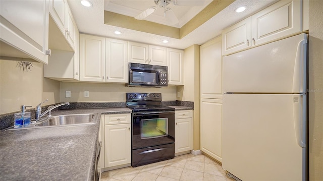 kitchen featuring black appliances, sink, light tile patterned floors, ceiling fan, and a tray ceiling