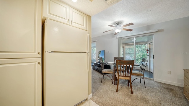 carpeted dining space featuring a textured ceiling and ceiling fan