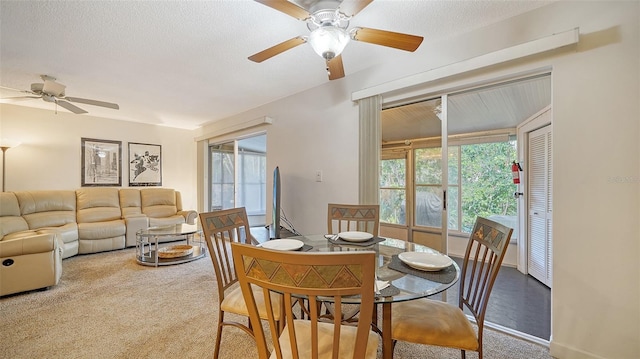 carpeted dining room featuring a textured ceiling and ceiling fan