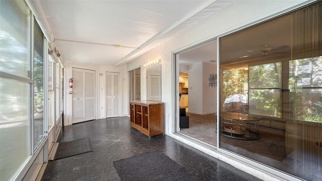 sunroom with ceiling fan and tile patterned floors