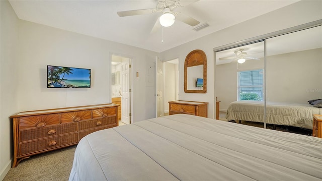 carpeted bedroom with a closet, ceiling fan, and ensuite bathroom