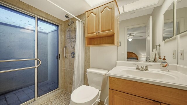 bathroom featuring toilet, ceiling fan, vanity, and walk in shower