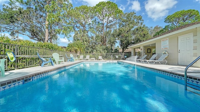 community pool featuring fence and a patio area