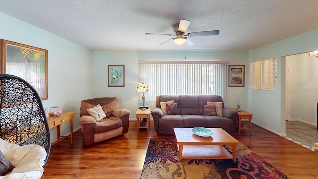 living room featuring hardwood / wood-style floors, a textured ceiling, and ceiling fan