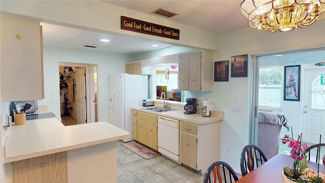 kitchen featuring white appliances, an inviting chandelier, sink, light tile patterned floors, and kitchen peninsula