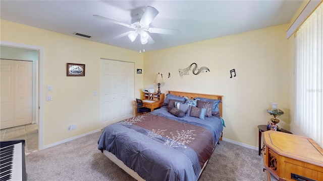 bedroom with ceiling fan, light carpet, and a closet