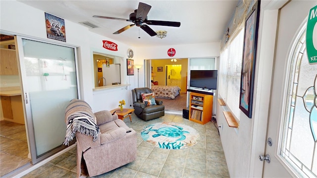 living room with tile patterned floors, ceiling fan, and sink