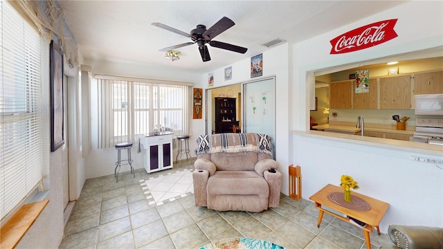 living area featuring ceiling fan and light tile patterned floors