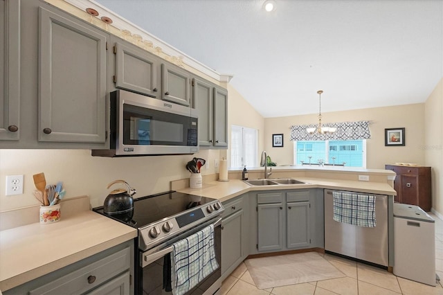 kitchen with gray cabinetry, light countertops, appliances with stainless steel finishes, a peninsula, and a sink