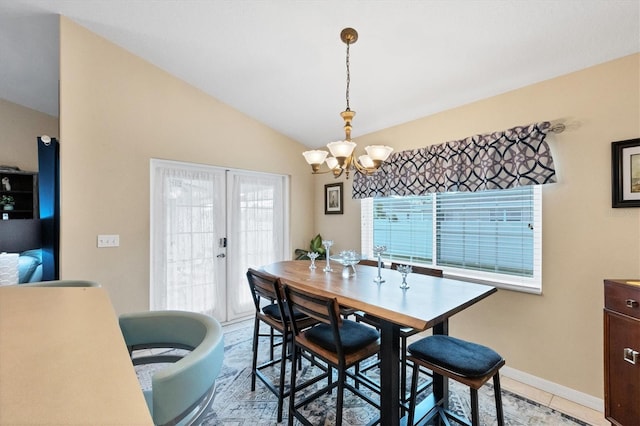 dining area with french doors, light tile patterned floors, an inviting chandelier, and vaulted ceiling