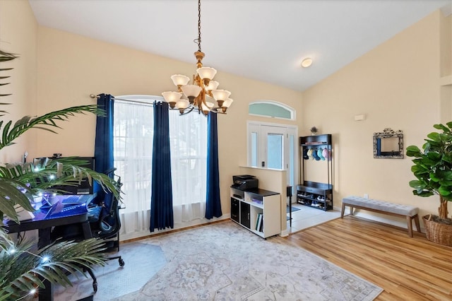 interior space featuring light wood-type flooring, a notable chandelier, and vaulted ceiling