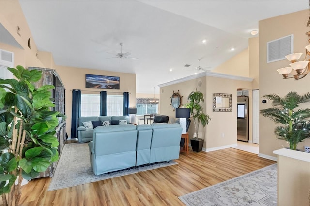 living room with high vaulted ceiling, light hardwood / wood-style floors, and ceiling fan with notable chandelier