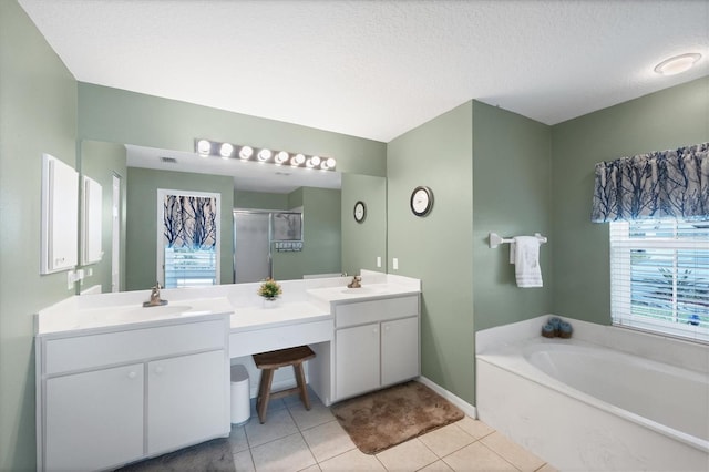 bathroom with vanity, shower with separate bathtub, a textured ceiling, and tile patterned floors