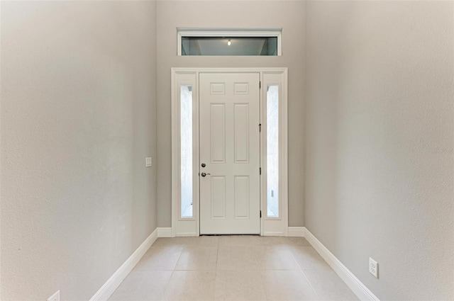 entryway with a wealth of natural light and light tile patterned floors