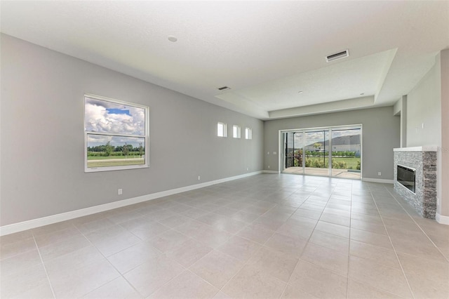 unfurnished living room featuring a fireplace, a textured ceiling, and light tile patterned floors