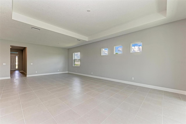 tiled empty room with a textured ceiling