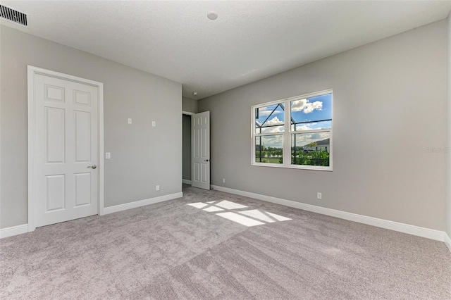 unfurnished bedroom with a textured ceiling and light carpet