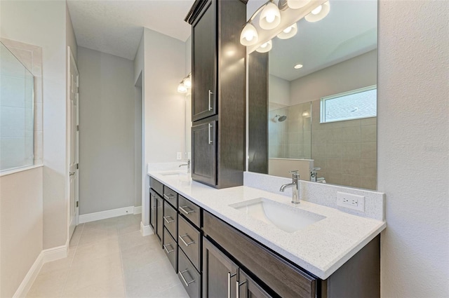 bathroom with tile patterned flooring, vanity, and tiled shower