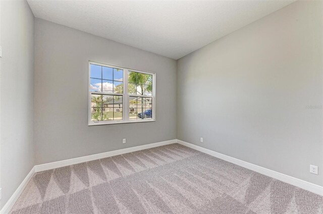 carpeted empty room featuring a textured ceiling