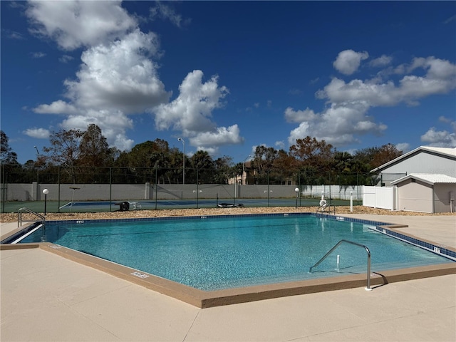 view of pool with tennis court