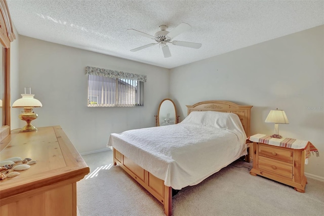 carpeted bedroom with ceiling fan and a textured ceiling