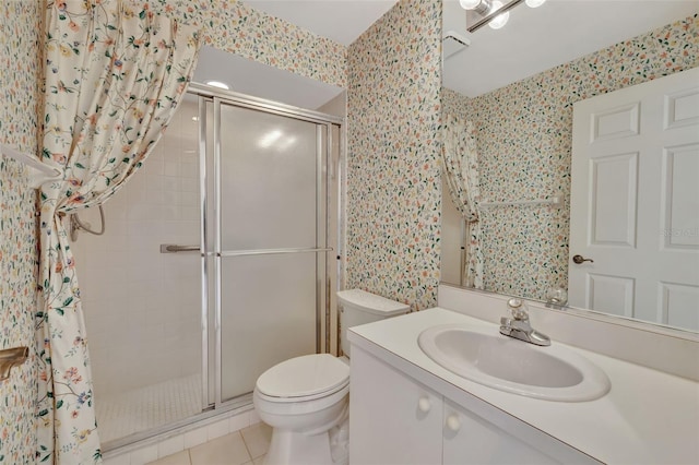 bathroom with tile patterned floors, toilet, vanity, and walk in shower