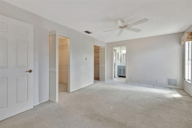 carpeted spare room with ceiling fan and a textured ceiling