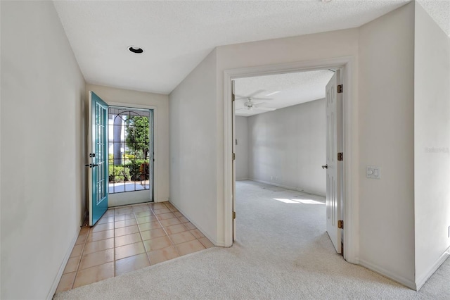 tiled foyer with french doors, a textured ceiling, and ceiling fan