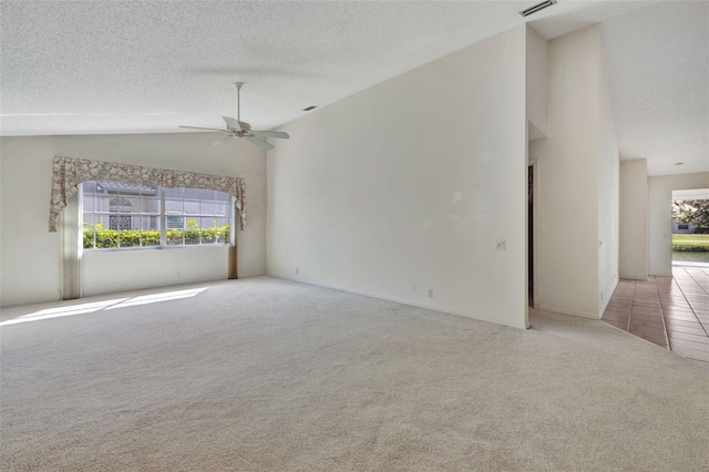 carpeted spare room featuring a textured ceiling, ceiling fan, and lofted ceiling