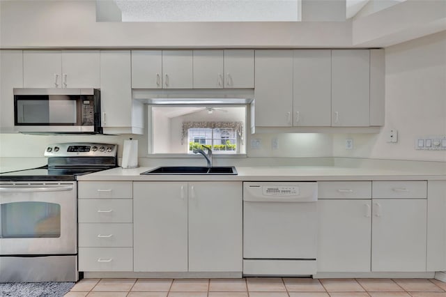 kitchen with white cabinets, sink, light tile patterned floors, and stainless steel appliances