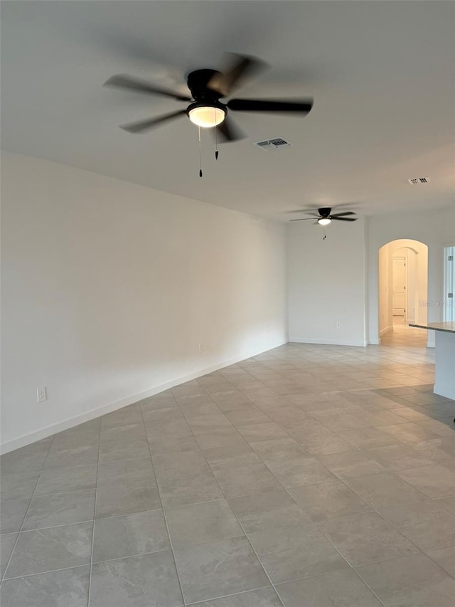 tiled spare room with ceiling fan