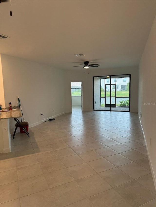 spare room with ceiling fan and light tile patterned flooring