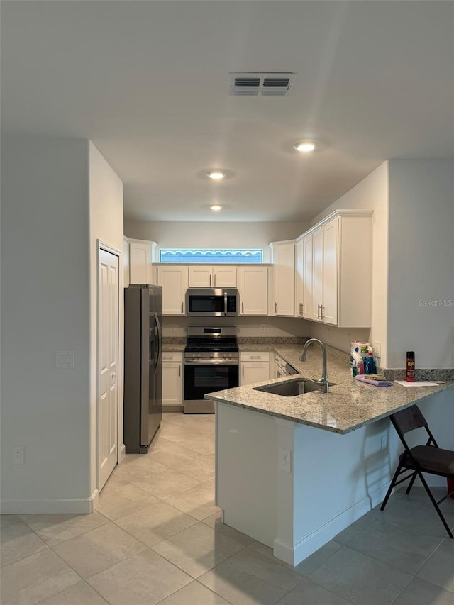 kitchen featuring kitchen peninsula, sink, white cabinets, and appliances with stainless steel finishes