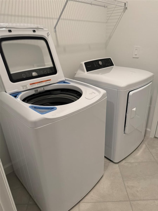 laundry room with light tile patterned floors and washing machine and clothes dryer