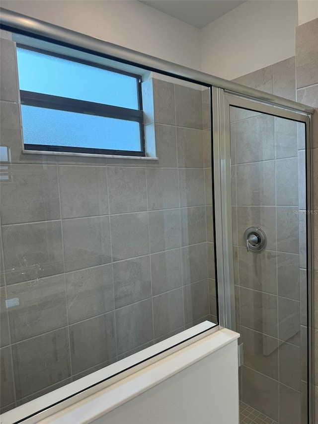 bathroom with a shower with door