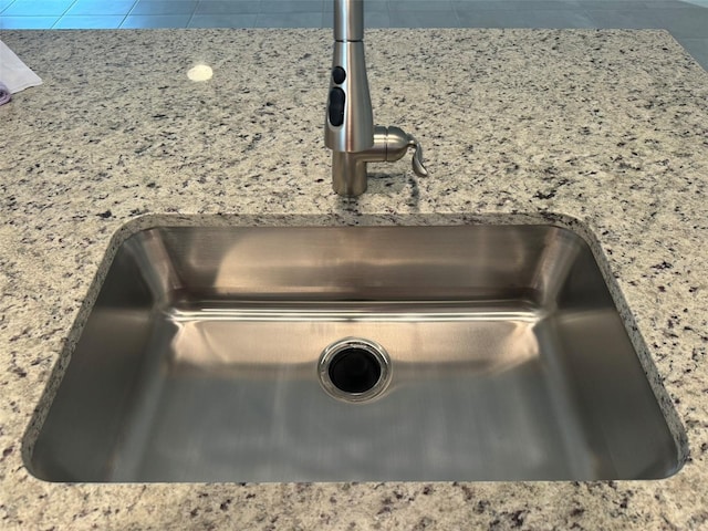 interior details with stone countertops and sink