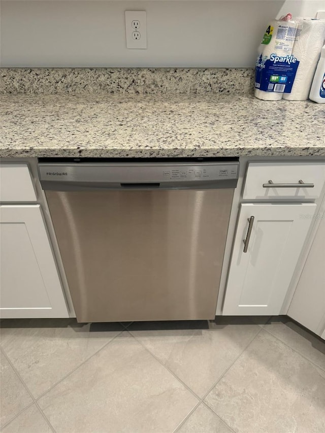 details with dishwasher, white cabinetry, and light stone countertops