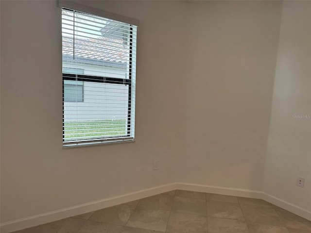 unfurnished room with plenty of natural light and tile patterned flooring