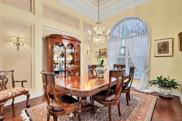 dining space featuring dark wood-type flooring, a chandelier, and ornamental molding