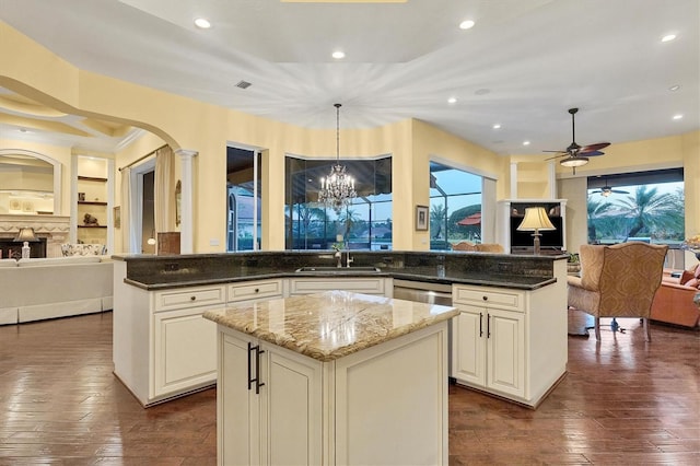 kitchen featuring dark stone counters, decorative light fixtures, dark hardwood / wood-style floors, and a kitchen island