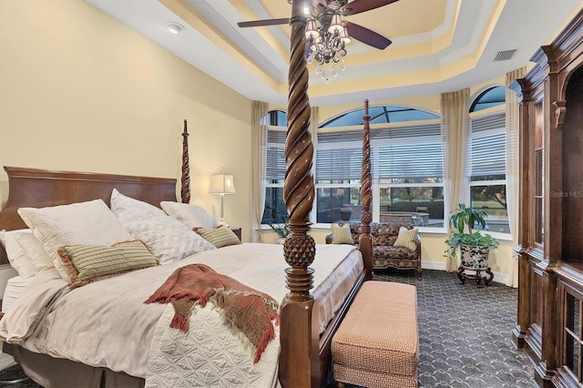 carpeted bedroom with ornamental molding, ceiling fan, and a tray ceiling