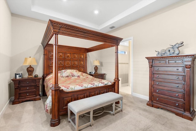 bedroom featuring light carpet and a raised ceiling